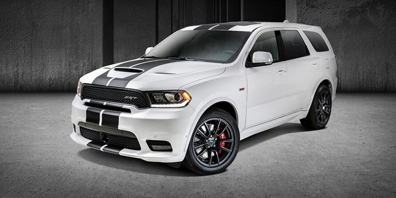 White 2020 Dodge Durango SRT with black racing stripes on the hood and roof, parked on a concrete floor.