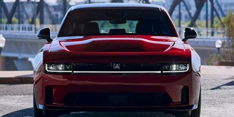 Frontal view of a dark red car with a full-width LED light bar and a black Airflow badge.