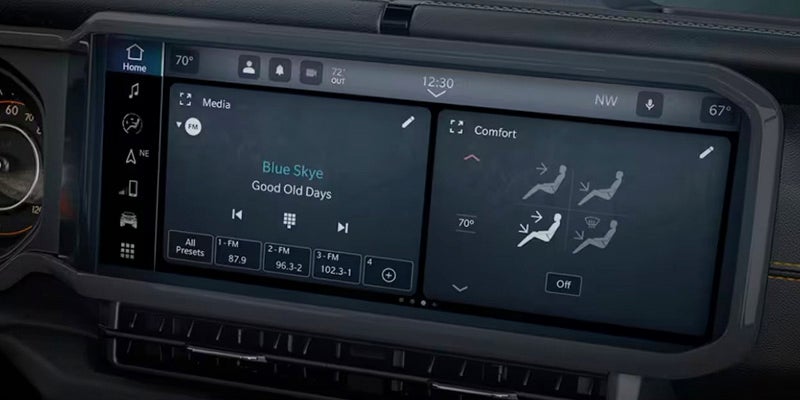 A Uconnect widescreen infotainment system displays media, comfort settings (including heated seats), and navigation.