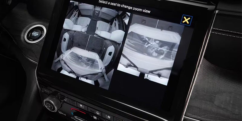 Car display showing two views of the interior: a full overhead view with seats, and a close-up of a baby in a car seat.