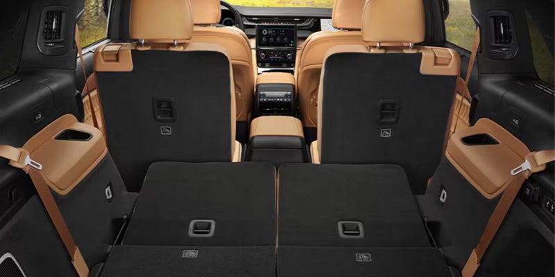 View from the rear of a car showing folded-down third-row seats, revealing a large cargo space.